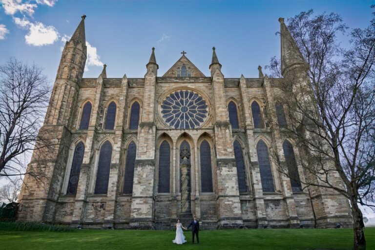 A romantic moment for a couple in front of the grand Durham Cathedral, captured with Durham wedding photography