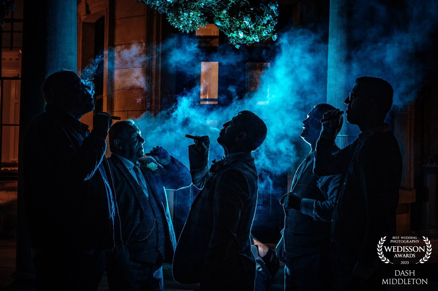 Cinematic luxury wedding photography of men celebrating with cigars